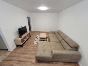 a living room with a couch and a tv at Apartmán Neva Šaľa in Šaľa