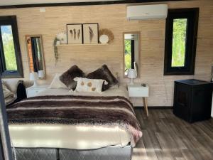 a bedroom with a large bed and two windows at Tiny House 2 a 3 personas Malalcahuello in Malalcahuello