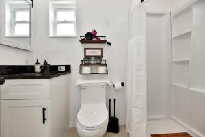 ein weißes Bad mit einem WC und einer Dusche in der Unterkunft Blue Mist Motel - Room # 3 in Daytona Beach