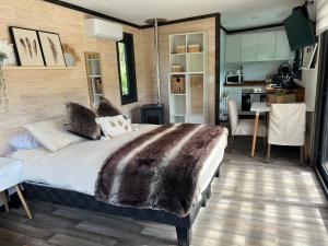 a bedroom with a large bed and a kitchen at Tiny House 2 a 3 personas Malalcahuello in Malalcahuello