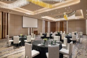 a conference room with tables and chairs and a projection screen at Marriott Riyadh Diplomatic Quarter in Riyadh