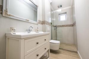 a white bathroom with a sink and a toilet at Provence in Arad