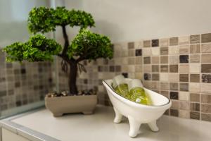 a bathroom with a bath tub with bottles and trees at Provence in Arad