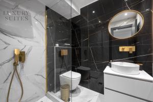a bathroom with a toilet and a mirror at Maison Cristal, The Luxury Suites in Thessaloniki