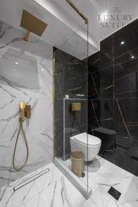 a bathroom with a toilet and a glass shower at Maison Cristal, The Luxury Suites in Thessaloniki
