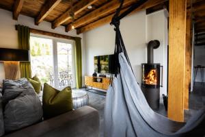 a hammock in a living room with a fireplace at SAUERLAND CHALETS - "Die Chalets am Bergelchen" in Winterberg