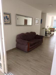 a large brown couch in a living room at Habitaciones Matrimoniales en Playa Pulpos HOSPEDAJE DELFINES HOUSE in Lurín
