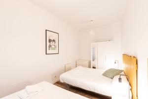 a white bedroom with a bed and a mirror at Apto Madrid Confort Centro in Madrid
