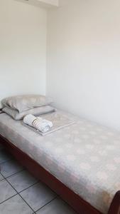 ein Bett mit zwei Kissen auf einem Zimmer in der Unterkunft Quarto no Jd. Satélite - Excelente localização na Zona Sul in São José dos Campos