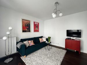 sala de estar con sofá verde y TV de pantalla plana en oompH Urban Oasis 1BR Escape en Varsovia