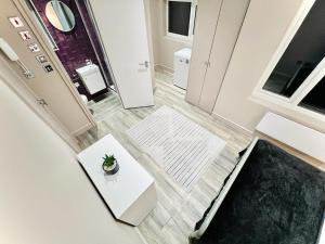 um quarto com uma mesa e uma planta no chão em High Standard Room, Super Location em Londres