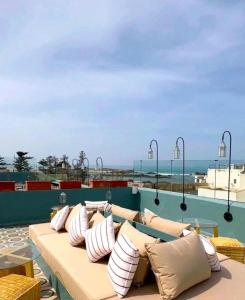 a couch on the roof of a building with the ocean at Le Palazzo in Essaouira