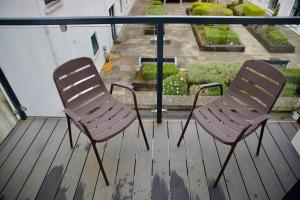 two chairs sitting on a balcony looking out at a garden at Mary St House 3A in Dublin
