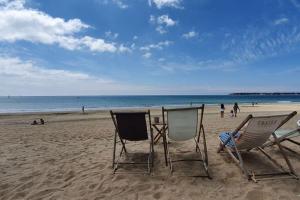 2 Stühle und ein Tisch am Strand in der Unterkunft Bulle de fraîcheur - Studio confort sur la plage in La Baule