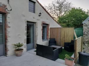 a patio with black chairs and a fence at Chez Henri in Les Herbiers