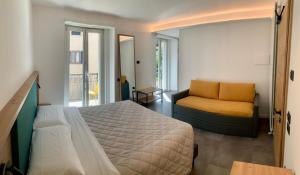 Hotel Locanda Alla Perla في ليدرو: غرفة نوم بسرير واريكة