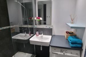 ein Badezimmer mit zwei Waschbecken und einem Spiegel in der Unterkunft Bulle de fraîcheur - Studio confort sur la plage in La Baule