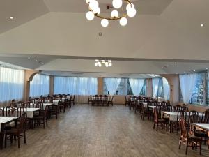 um salão de banquetes com mesas e cadeiras e um lustre em Hotel Mountain View Inn em Gusinje