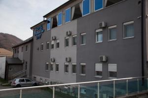 a building with a car parked in front of it at Hotel Mountain View Inn in Gusinje