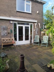 a patio with two chairs and a house at Hoekhuis met tuin op het zuiden. in Gouda