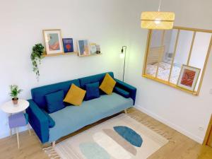 a living room with a blue couch and a table at Cosy 2 pièces au coeur de la ville à 10 min du centre de Paris in Maisons-Alfort