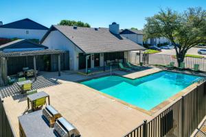 a swimming pool in front of a house at Convenient Grand Prairie Apartment with Balcony in Grand Prairie