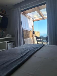 a bedroom with a bed with a view of the ocean at Casatua Pousada in Juquei