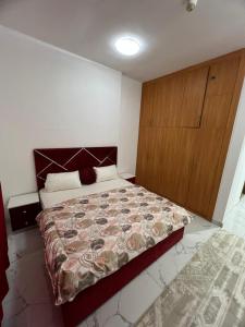 ein Schlafzimmer mit einem großen Bett und einem Holzschrank in der Unterkunft 2bhk oasis tower in Ajman 