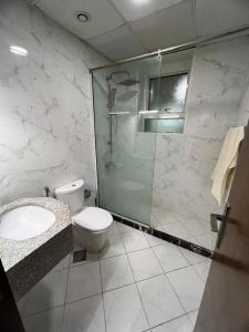 ein Bad mit einer Dusche, einem WC und einem Waschbecken in der Unterkunft 2bhk oasis tower in Ajman 