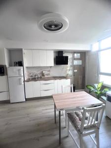 a kitchen with a table and a kitchen with white cabinets at Relax apartamento 7 in Las Palmas de Gran Canaria