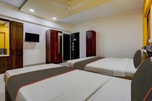 a hotel room with two beds and a tv at Collection O Rio Corporate House in Mumbai