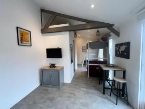 a living room with a tv and a table and chairs at studio bocagère in Amblainville