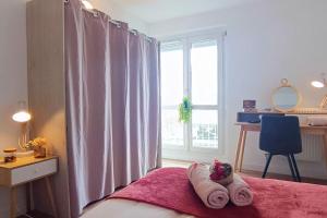 un dormitorio con una cama con toallitas. en Appartement neuf - 3 chambres - 6 personnes - 73m² vue sur la ville, en Caen