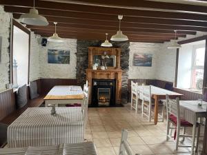 un restaurante con chimenea, mesas y sillas en The Coastguard House @ Tigh T.P. en Ballydavid