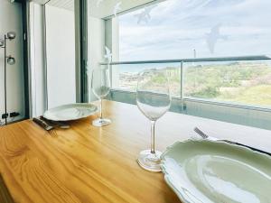 two wine glasses sitting on a wooden table with a window at Studio à la Chaume avec une superbe vue sur le Bassin Dombret 2 pers in Les Sables-dʼOlonne +3 photos
