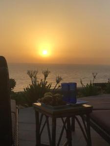 einen Tisch mit einem Teller Essen und einem Sonnenuntergang in der Unterkunft Breath Taking View (For Families) in Ain Suchna