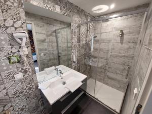 a bathroom with a sink and a shower at Logis Hotels - Auberge de l'Île - Hôtel 3 étoiles et Restaurant in Creysse +84 photos