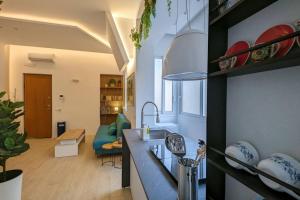 a kitchen with a sink and a living room at Don Armando al Massimo in Palermo