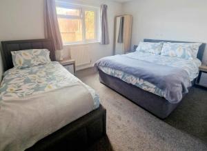 1 dormitorio con 2 camas y ventana en Tanglewood en West Ashton