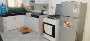 a kitchen with a refrigerator and a stove at Mawade Studio Apartment in Ukunda