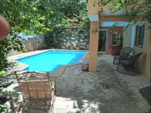 a pool with chairs next to a house at Villa rozenuda in El Higo