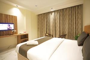a hotel room with a bed and a television at Hotel GOOD LUCK HOUSE Near Delhi Airport in New Delhi