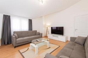 sala de estar con sofá y TV en Hillside Vista Apartments en Tivat