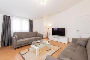 un soggiorno con un divano e una TV di Hillside Vista Apartments a Tivat