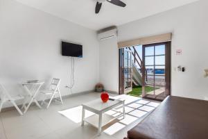 uma sala de estar branca com uma mesa e uma televisão em Jr Suite 4 - Playa Arcangel em Rosarito