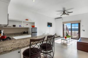 uma cozinha com dois bancos de bar e um balcão em Jr Suite 4 - Playa Arcangel em Rosarito