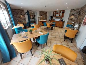 a restaurant with wooden tables and yellow chairs at Logis Hotels - Auberge de l'Île - Hôtel 3 étoiles et Restaurant in Creysse