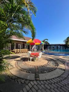 a patio with a table and chairs and an umbrella at Ice Bear Bar & Tourist Inn in Dauis