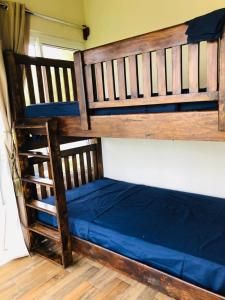 Ce lit superposé se trouve dans un dortoir doté d'un matelas bleu. dans l'établissement Casa Familiar Birds, Puerto San Jose, à La Barrita