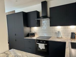 a kitchen with black cabinets and a stove top oven at Entire Apartment in Waterloo in Waterloo